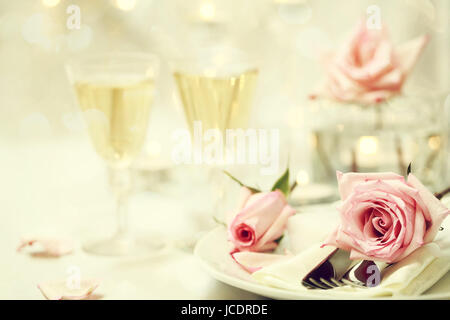 Réglage de la table et les verres avec des roses rose Banque D'Images