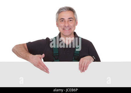 Mâle mature Gardner Holding Placard sur fond blanc Banque D'Images