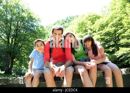 Portrait de famille assis sur un pont dans la forêt Banque D'Images