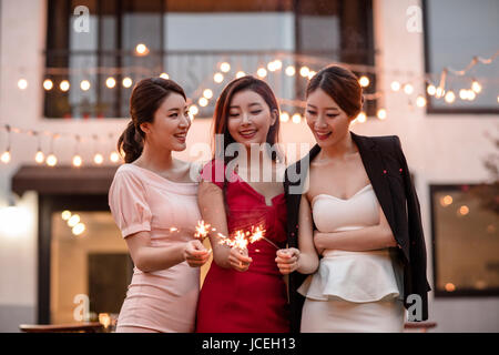 Smiling women avec pétards at party Banque D'Images