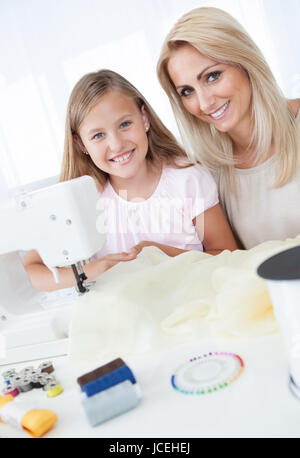 Portrait d'une belle jeune fille avec sa mère à coudre à la maison Banque D'Images