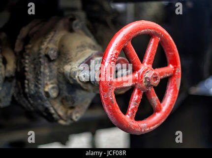 Une valve de roue rouge grimmy réglementant la circulation des liquides de base industriels. Banque D'Images