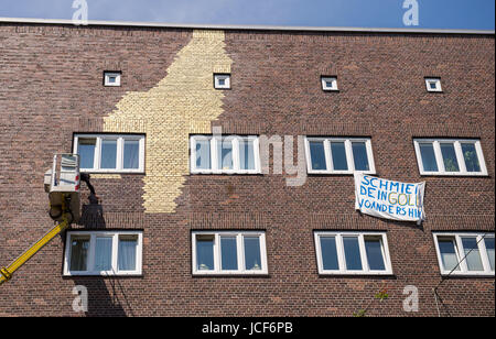 L'artiste Boran Burchhardt photographies couleur bleu des taches sur la façade de la maison dans le quartier de Veddel, Hambourg, Allemagne, 15 juin 2017. Deux jours seulement après le début de l'art projet "Veddel doré' des inconnus ont enduit le mur avec de la peinture. L'artiste a commencé le mur Burchardt placage façade avec de l'or sur le 13 juin 2017. Photo : Daniel Bockwoldt/dpa Banque D'Images