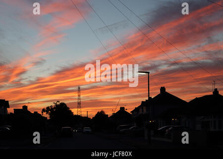 Epsom, Surrey, UK. 15 Juin, 2017. Nuages orange éclatant avec un beau coucher de soleil sur les toits dans la banlieue de Surrey. Credit : Julia Gavin UK/Alamy Live News Banque D'Images