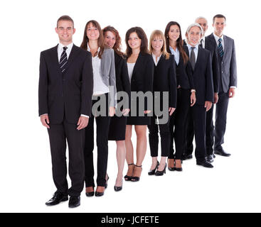 Groupe de personnes à la confiance des entreprises dans une équipe ou une société de personnes debout dans une rangée en quinconce smiling at the camera isolated on white Banque D'Images