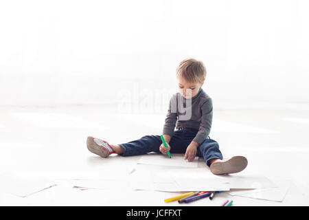 Petit garçon donne une image de crayons à la maison Banque D'Images