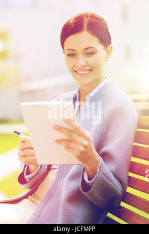 Businesswoman reading notes dans le bloc-notes en plein air Banque D'Images