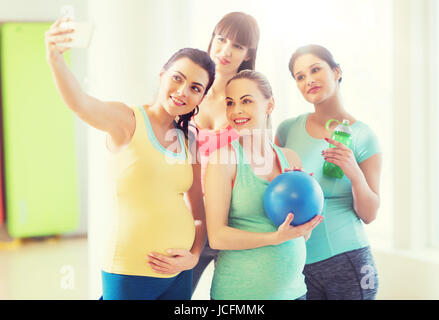 Les femmes enceintes prenant en selfies smartphone dans une salle de sport Banque D'Images