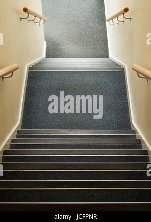 Escalier descendant dans immeuble de bureaux avec des rambardes et dalles de moquette bleue, aucun voyage dangers et pas de barrières de sécurité de portes. Au milieu d'atterrissage Banque D'Images