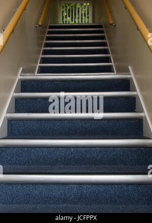 Escalier qui monte en immeuble de bureaux avec des tapis bleus, à l'étage avec l'absence d'obstacles ou dangers voyage. L'atterrissage à mi-hauteur de l'escalier Banque D'Images