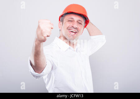 Portrait de l'architecte wearing hardhat faisant le geste gagnant montrant fist sur fond gris Banque D'Images