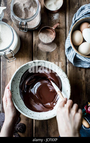 Glaçage au chocolat fondu d'être remué dans un bol à mélanger Banque D'Images