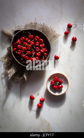 Cerises rouges juteux dans une cuvette d'argile sur une table en marbre sur une vue supérieure Banque D'Images