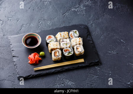 Rouleaux de sushi Yin Yang forme sur ardoise en pierre sur pierre noire espace copie d'arrière-plan Banque D'Images