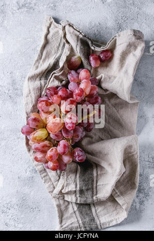 Bouquet de rose rouge raisins mûrs sur le linge humide cuisine serviette sur gris bleu texture background. Vue de dessus avec l'espace Banque D'Images