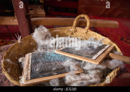 Détail de la laine de mouton à brosse peigne dans un panier en osier, trouvés dans un magasin traditionnel à Ait-ben-Haddou, Maroc Banque D'Images