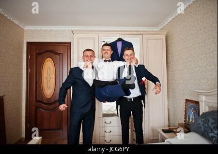 Beau palefrenier et groomsman en chambre hugging à côté du miroir. Banque D'Images