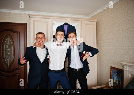 Beau palefrenier et groomsman en chambre hugging à côté du miroir. Banque D'Images