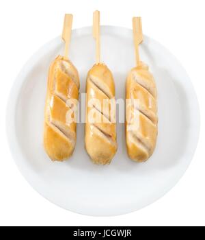 La nourriture et la cuisine, vue du haut de trois Saucisses cuites sur la brochette en bois servi sur plat blanc. Banque D'Images