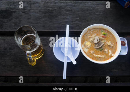 Laksah Repas au Sarawak en Malaisie. Malaise d'aliments traditionnels avec de la bière. Banque D'Images