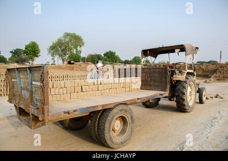 AMRITSAR, Punjab, INDIA - 21 avril 2017 : un travailleur indien chargement de briques dans un vieux camion Banque D'Images