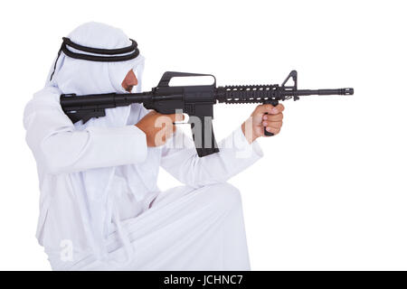 Mature Man Holding Gun islamique sur fond blanc Banque D'Images