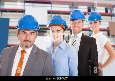 Portrait de Professionnels Architectes portant casque et Standing in a Row Banque D'Images