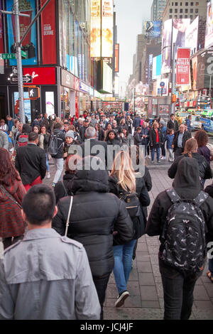 Les personnes qui traversent la pleine concordance de trottoir occupé dans la soirée soirée à Times Square New York City USA Banque D'Images