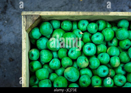 Contexte emballés dans des boîtes de pommes vertes en vente sur le marché local Banque D'Images