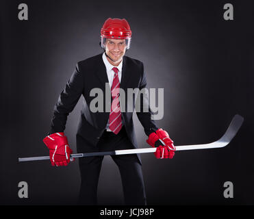 Portrait Of A Young Businessman habillé en Joueur de Hockey sur fond noir Banque D'Images