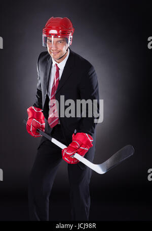 Portrait Of A Young Businessman habillé en Joueur de Hockey sur fond noir Banque D'Images