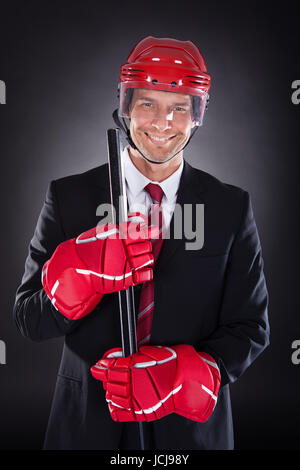 Portrait Of A Young Businessman habillé en Joueur de Hockey sur fond noir Banque D'Images