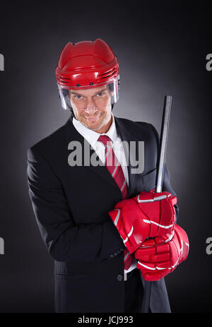 Portrait Of A Young Businessman habillé en Joueur de Hockey sur fond noir Banque D'Images