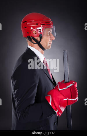 Portrait Of A Young Businessman habillé en Joueur de Hockey sur fond noir Banque D'Images