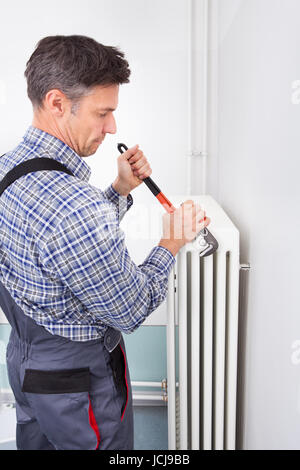 Portrait d'homme plombier radiateur fixation à l'aide d'une clé Banque D'Images