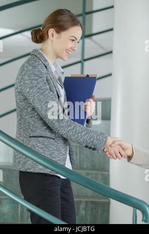 Cheerful businesswoman et client handshaking Banque D'Images