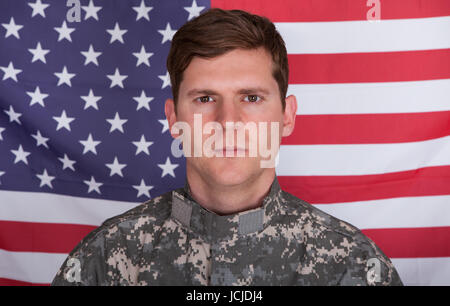 Portrait de soldat grave standing in front of Us Flag Banque D'Images