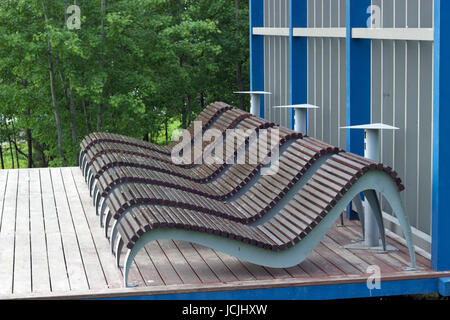 Zone de loisirs dans le parc, chaises longues en bois à l'ombre d'un arbre dans un parc sur la rive du fleuve Banque D'Images