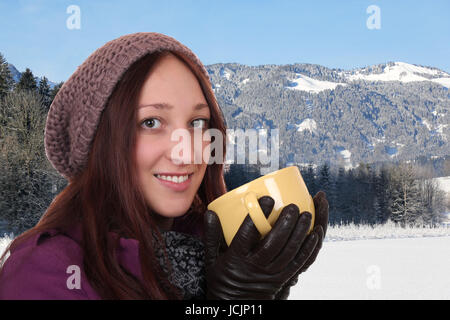 Portrait einer jungen Frau beim Trinken mit Tasse Tee im Winter in den Bergen Banque D'Images