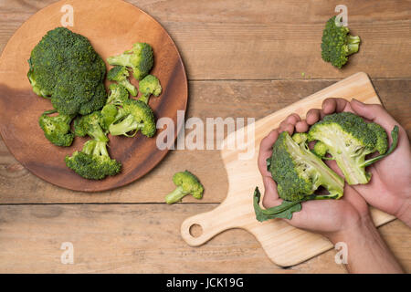 Vue du dessus de la main du Chef de cuisine pour le brocoli de coupe Banque D'Images