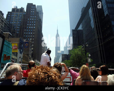 Tour en bus à travers la ville de New York avec l'Empire State Building au loin Banque D'Images