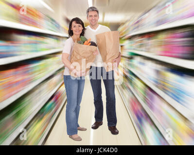 Couple heureux avec des sacs d'épicerie. Isolated on white Banque D'Images