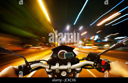 La conduite d'une moto motard rides le long de la rue de ville , scène de nuit . Angle de vue à la première personne . Banque D'Images