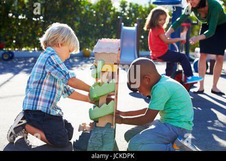 Deux garçons jouant avec jouet en jeu pour enfants Banque D'Images