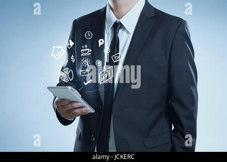 Successful businessman using hand phone contrôle sur les tâches quotidiennes concept icônes dans son téléphone à la main. Banque D'Images