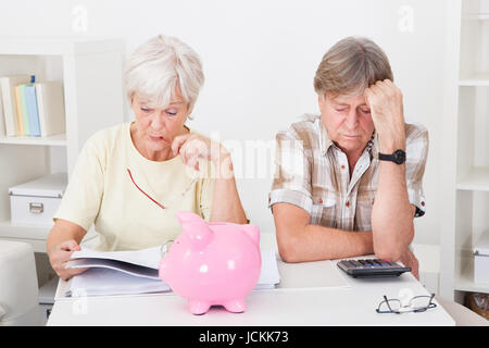 Portrait de Senior Couple bouleversé le calcul de finances à la maison Banque D'Images