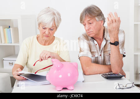 Portrait de Senior Couple bouleversé le calcul de finances à la maison Banque D'Images