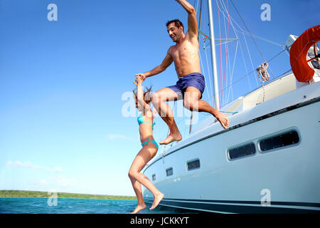 Jeune couple sauter dans l'eau à partir de la location Banque D'Images