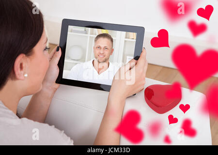 Portrait of young woman having conversation vidéo avec copain sur digital tablet Banque D'Images