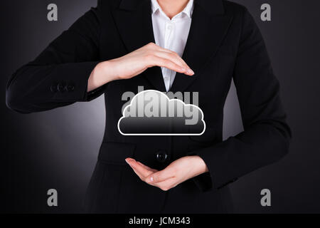 Portrait of businesswoman holding cloud computing icône sur fond noir Banque D'Images